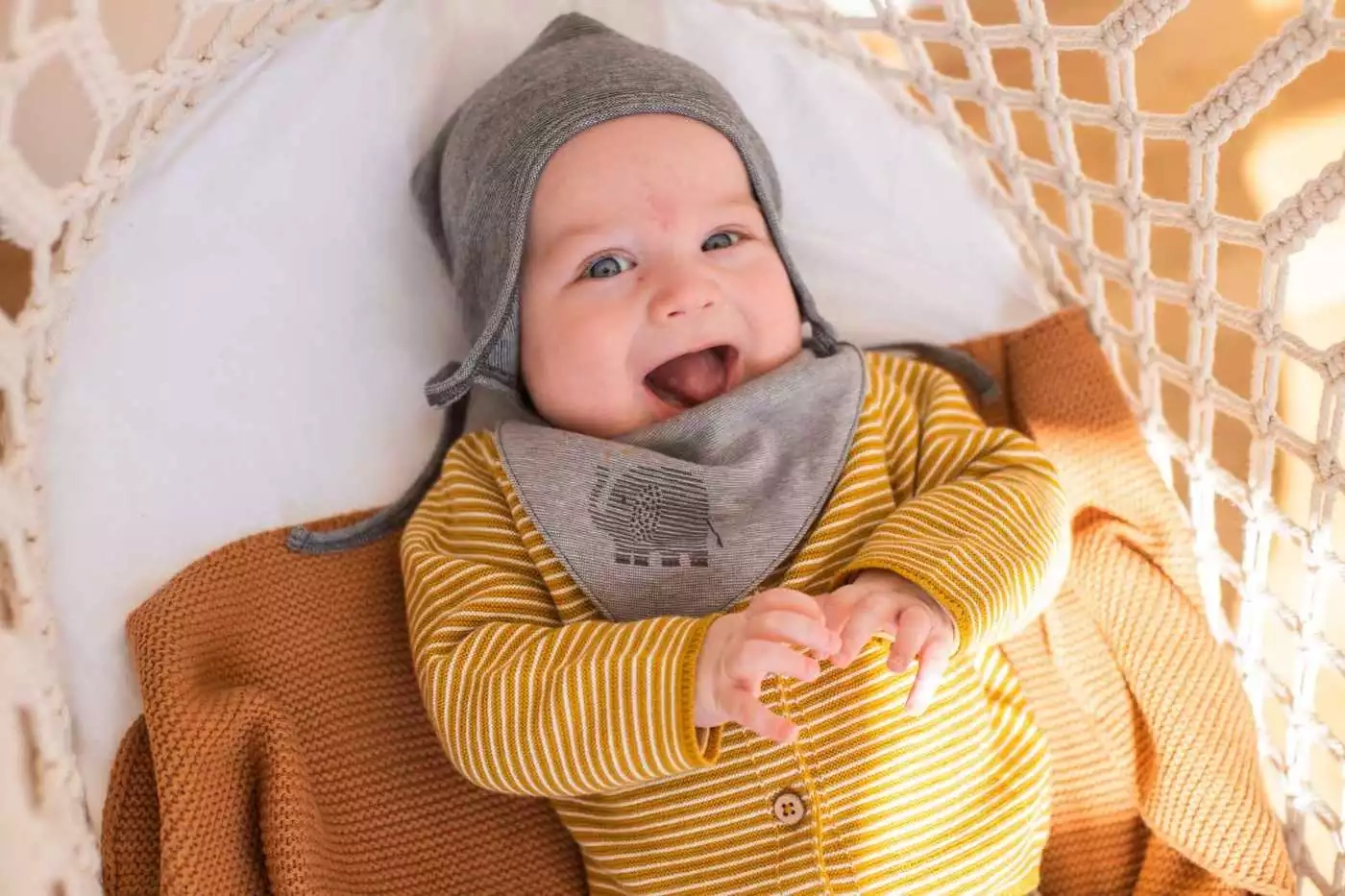 Baby ein in einem gelben pullover und grauem hut.