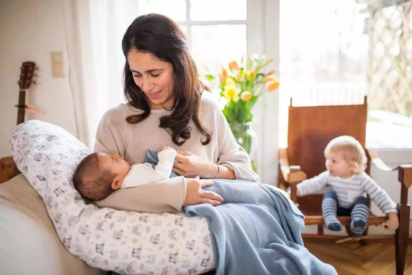 Eine frau, die ein baby hält, während sie auf einer.