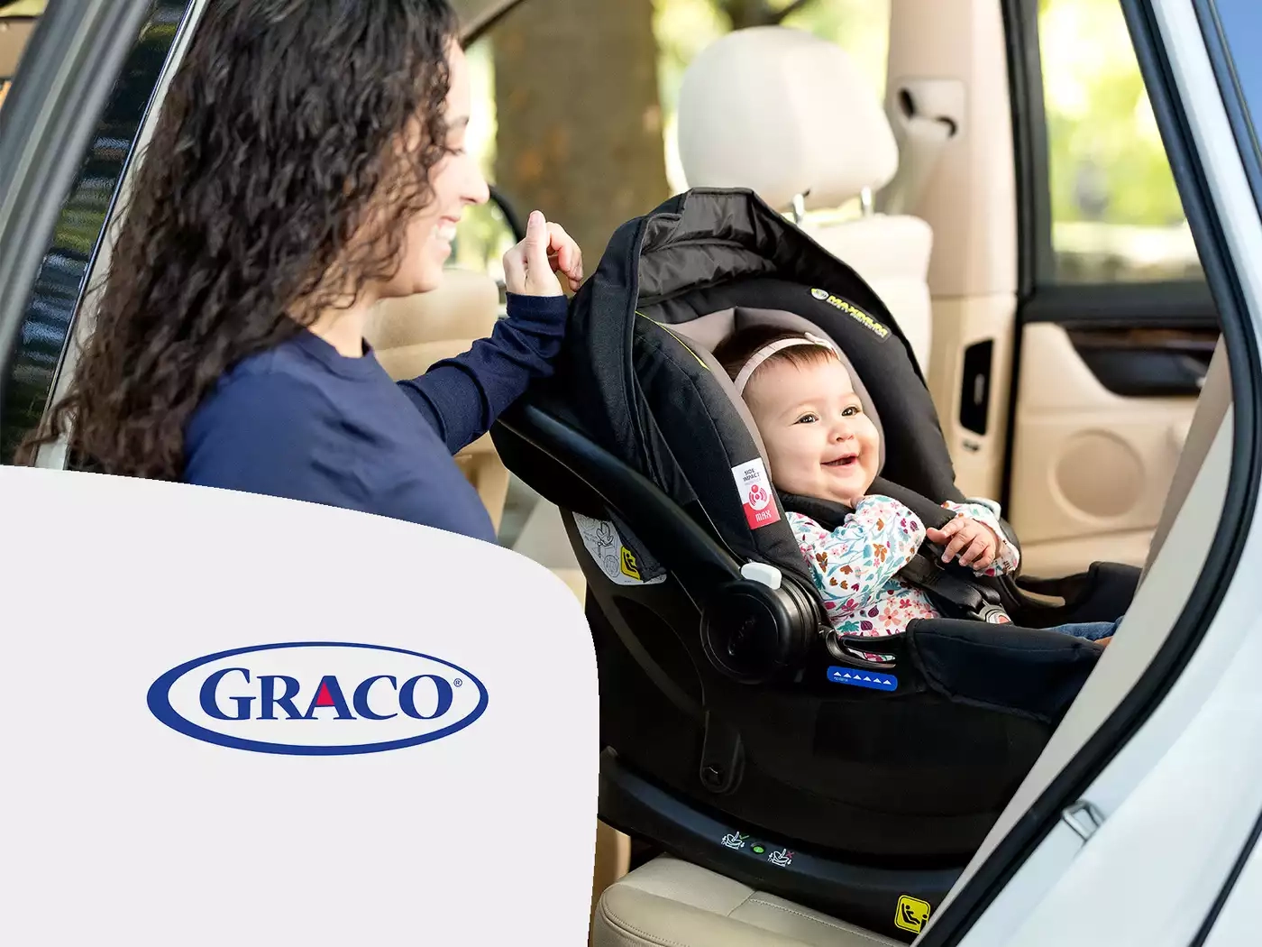 Eine frau, die ein baby auf einem autositz hält.