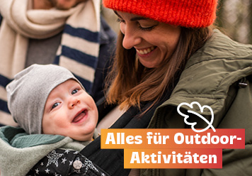 Baby mit Mütze in der Trage bei seiner Mutter. Alles für Outdoor-Aktivitäten.