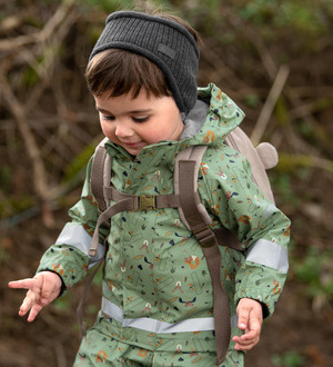 Ein Kleinkind trägt einen wetterfesten, gemusterten Outdoor-Anzug und ein Stirnband.